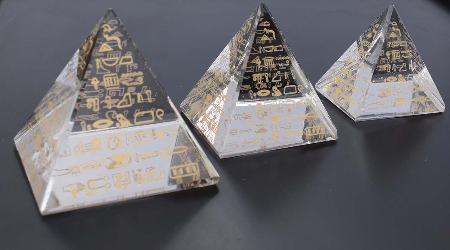 Three clear glass pyramids decorated with gold-coloured Egyptian motifs, as shown in the Amazon listing